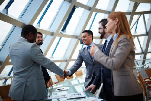 Trademark lawyers shake hands in a conference room